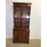 An Edwardian style two piece glazed display cupboard. Double glazed doors to three shelves with