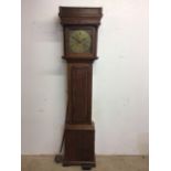 An oak cased eight day grandfather clock with brass face engraved Sam L Hartley. With pendulum and