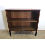 An Abbess small mid century glazed bookcase with sliding doors and metal legs. W:76cm x D:31cm x H: