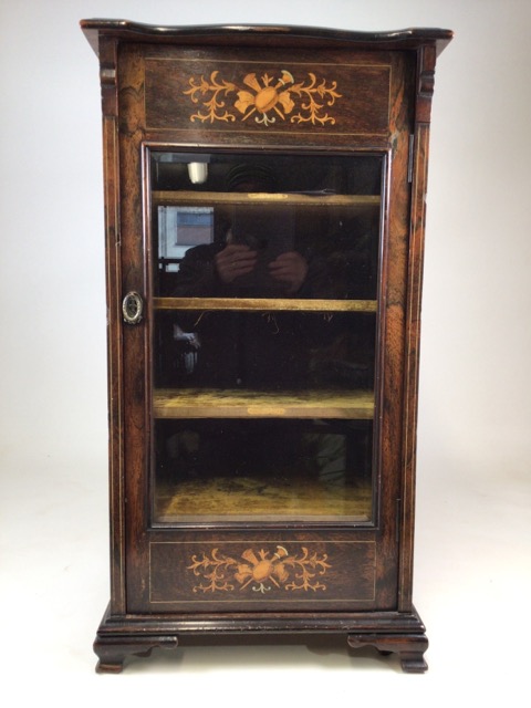 A Gillows style rosewood music cabinet with extensive inlay, glazed door to material lined