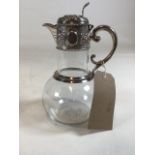 A Victorian sterling silver topped claret jug with scrolling floral decoration and vacant