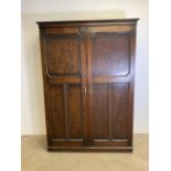 An early 20th century gentlemanâ€™s oak double wardrobe by Awlyn furniture with fitted shelves,