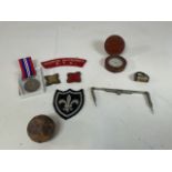 A collection of military items including the war medal 1939-1945, a cannon ball, a wooden cased