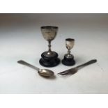 Sterling silver items to include two small trophies on turned wooden plinths. 3.1oz.