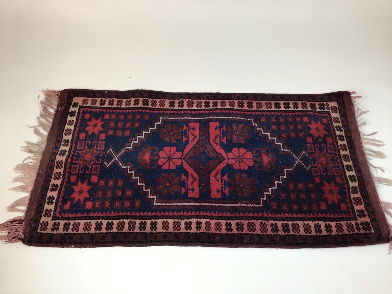 A Turkish prayer rug, maroon and navy. W:103cm x D:57cm x