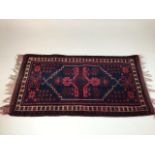 A Turkish prayer rug, maroon and navy. W:103cm x D:57cm x