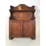 A Victorian mahogany wall cupboard with interior shelves. With turned chamfered and carved details