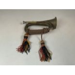 A vintage brass bugle with bugle cord and tassels. No visible makers mark Length: 28cm