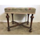 A Victorian mahogany upholstered stool with turned legs and X frame stretcher bar to base. With