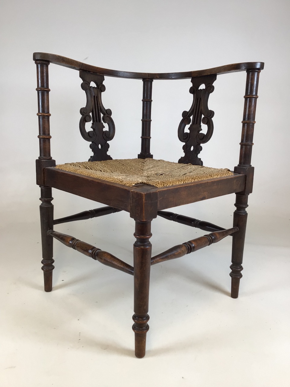 A 19th century rattan seated corner chair with curved back and lyre supports. W:61cm x D:61cm x H: