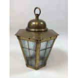 A brass hanging lantern with opaque glass and flower head decoration. Stamped Peerage made in