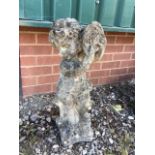 A reconstituted stone statue of a cherub playing the tambourine. H:60cm