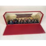 A boxed diorama of the Tour de France with nine metal cyclists and a car. Titled L arrive du Tour de