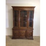 A reproduction glazed two piece display cupboard with decorated glass and cupboard beneath. W: