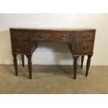 A small curved ladies desk with large central drawer with two drawers either side with brass