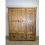 A modern oak triple wardrobe with deep drawers to base and interior hangings rail to top.
