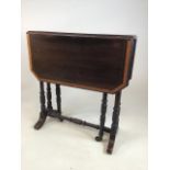 A small Edwardian mahogany inlaid Sutherland table with turned legs and stretcher with ceramic