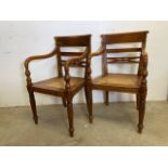 A pair of rattan seated bent wood bar back armchairs. One arm loose. Seat height H:45cm