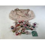 A vintage fabric sewing bag together with vintage cotton reels