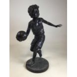 A large bronzed sculpture of a boy playing basket ball.W:33cm x D:33cm x H:78cm