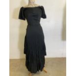 An early twentieth century black flounced dress with built in boned corset