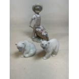 Three lladro figurines comprising a boy pushing a wheel barro model number 1283 and two polar bears