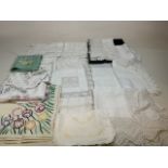 A collection of vintage lace trimmed and embroidered table linen, including table cloths, tray