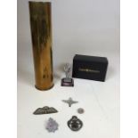 A collection of military items including cap badges, vintage felt parachute wings, a pewter figurine