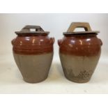 A pair of pottery storage jars with wooden lids, marked London. H:43cm