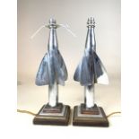 A pair of aluminium ships log rotators of a four step base tri metal base. H:40cm