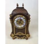 An oak cased early 20th century 8 day Clock with brass ormolu style decoration. With brass feet
