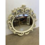 An white painted decorative rococo style mirror, slightly oval with bevelled edge. W:110cm x H: