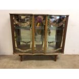 A glazed mid century display cabinet with gilt decoration mirrored back and glass shelves. W:106cm x