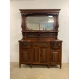 An early 20th century two piece mirrored sideboard with carved panels and supports and bevelled