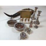 A collection of silver plate and a cows horn. Includes salts, pepperettes, candlesticks, wine