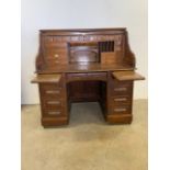 A Victorian oak pedestal roll top desk of large proportions with multi drawer interior secretaire,