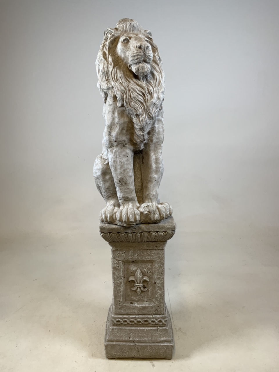 A reconstituted stone lion on square plinth. W:23cm x D:23cm x H:102cm
