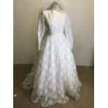 A vintage lace wedding dress and veil. Dress has full skirt with flounced back