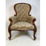 A Victorian mahogany button backed chair with floral upholstery finish. On metal castors. Seat