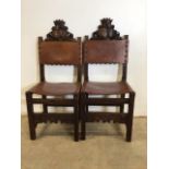 A pair of carved oak chairs with leather seats. Seat height H:45cm