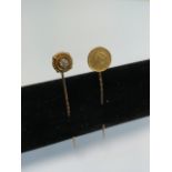 Two stick pins, one with an 1854 gold dollar and the other a yellow metal diamond studded pin.