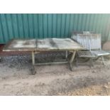 A large extending teak garden table and four folding chairs. By . Table is shown with one leaf