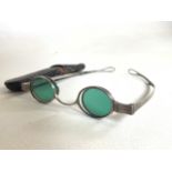 A pair of white metal framed oval lens sunglasses with green and clear glass lenses.