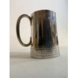 A hallmarked silver mug with geometric pattern.