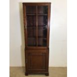 An early 20th century mahogany small glazed bookcase with interior shelves and cupboard below. W: