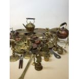 A quantity of brass and copper items to include kettles, candle sticks, bells, trays nut crackers