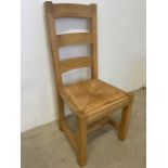 A set of six heavy pine farmhouse chairs with rush seats and chamfered detail and square peg