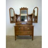 A decorative 20th century dressing chest with three drawers on ceramic castors. Triple mirrored