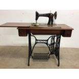 A singer sewing a machine with cast iron and oak table base.