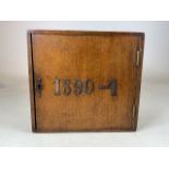 A small oak cupboard with interior shelf with 1890-4 lettering. W:30cm x D:21cm x H:28cm